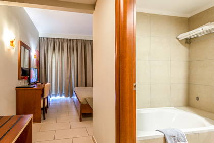 Pokój hotelowy z łazienką i sypialnią.
