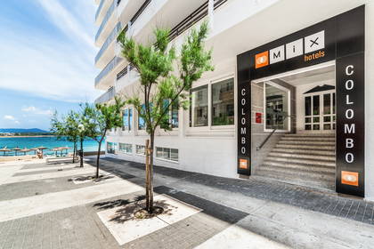 Hotel Mix Colombo z zewnątrz. Widoczne wejście i drzewa.