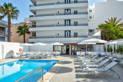 Hotel z basenem i leżakami do opalania.