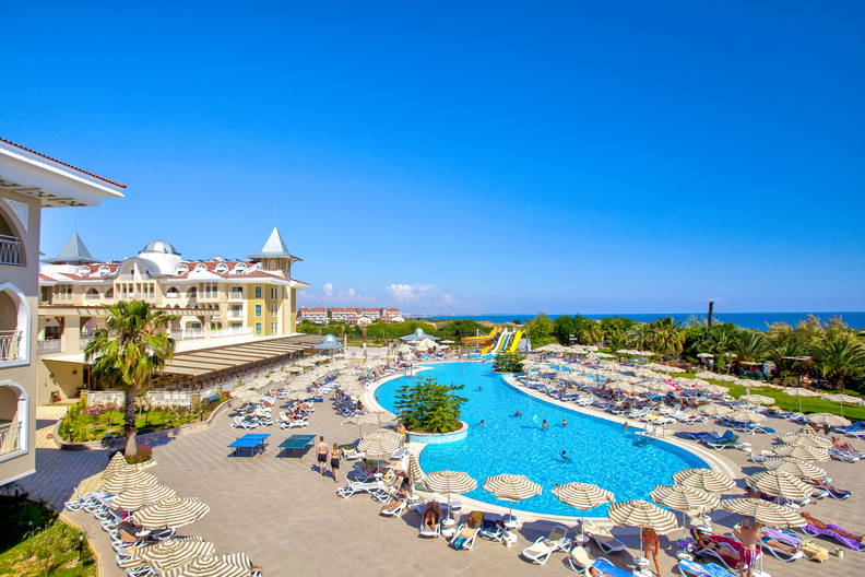 Basen w ośrodku wypoczynkowym z leżakami i parasolami.