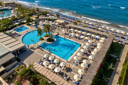 Hotel z basenami i plażą widziany z góry.