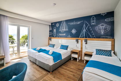 Pokój hotelowy z dwoma łóżkami i balkonem.