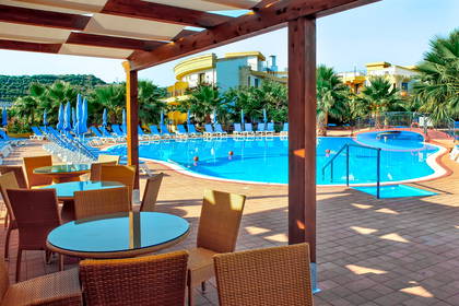 Widok z baru na basen, palmy i hotel.