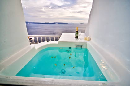 Jacuzzi z widokiem na morze, szampan i świece.