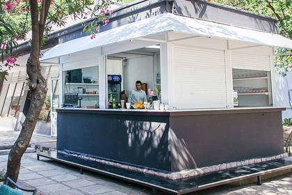 Restauracja z zewnętrznym barem i stolikami.