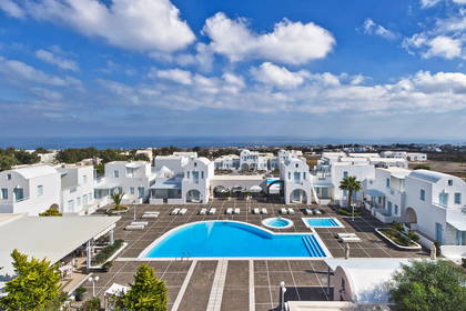 Białe budynki z basenem na greckiej wyspie Santorini, widok z góry.
