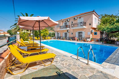 Basen hotelowy z leżakami i parasolami.