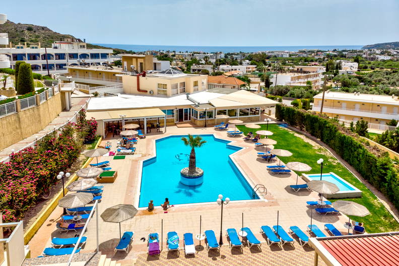 Hotelowy basen z leżakami i parasolami, widok z góry.