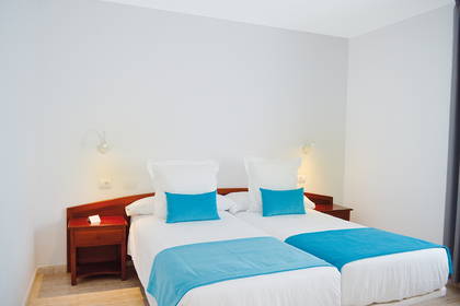 Pokój hotelowy z dwoma łóżkami pojedynczymi.