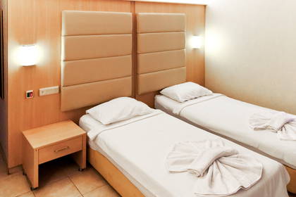 Pokój hotelowy z dwoma łóżkami i szafką nocną.