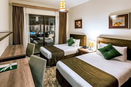 Pokój hotelowy z dwoma łóżkami i widokiem na basen.