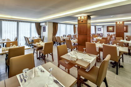 Wnętrze restauracji z nakrytymi stolikami i krzesłami.