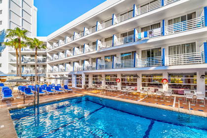 Hotel z basenem i leżakami do opalania.