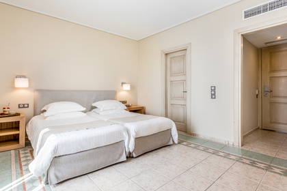 Pokój hotelowy z dwoma pojedynczymi łóżkami i poduszkami.