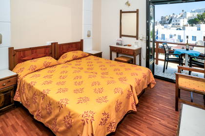 Pokój hotelowy z balkonem i widokiem na miasto.