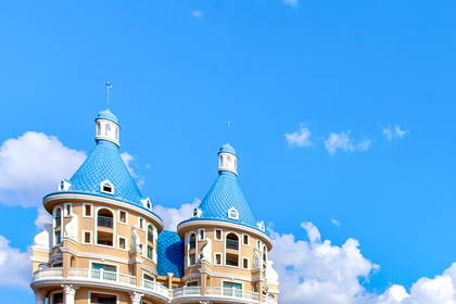 Hotel z basenem na tle błękitnego nieba.