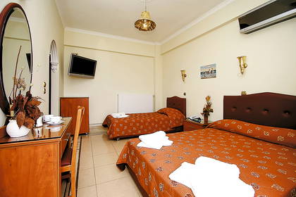 Pokój hotelowy z dwoma łóżkami, biurkiem i telewizorem.