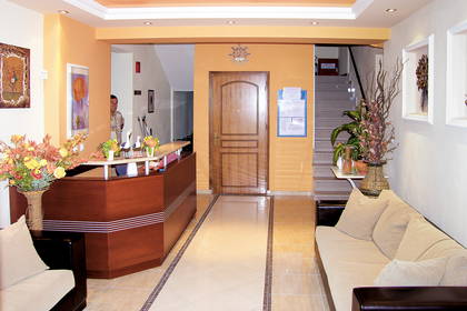 Lobby hotelowe z recepcją i sofą.