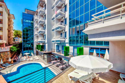 Hotel z basenem i leżakami.
