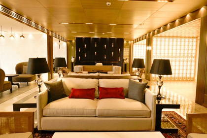 Salon hotelowy z sofami, stolikami i lampami.