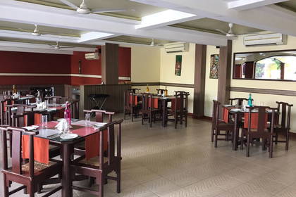 Wnętrze restauracji z nakrytymi stolikami i krzesłami.