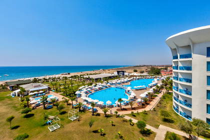 Widok z góry na basen hotelowy, plażę i ocean.