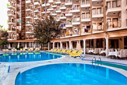 Basen hotelowy z leżakami i restauracją.