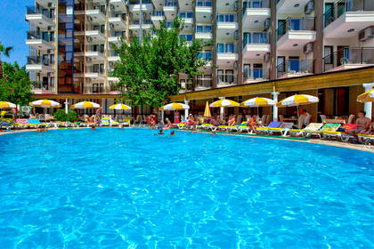 Kompleks hotelowy z basenem i wypoczywającymi osobami.