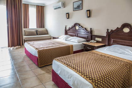 Pokój hotelowy z dwoma łóżkami i sofą.