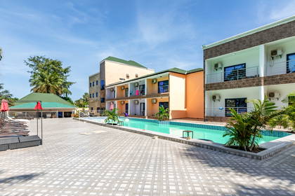 Kompleks hotelowy z basenem i leżakami.