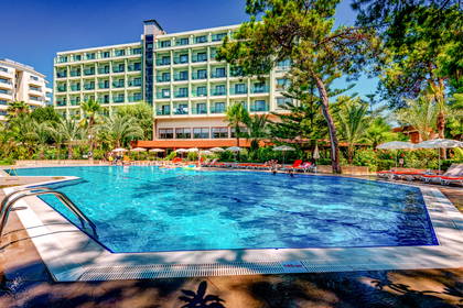 Hotel z basenem i leżakami do opalania.