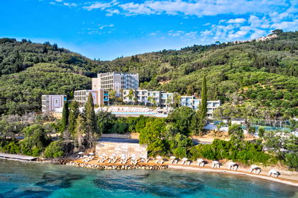 Hotel na wzgórzu z widokiem na plażę i turkusową wodę (widok z lotu ptaka).