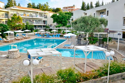 Basen z leżakami i parasolami przy hotelu.