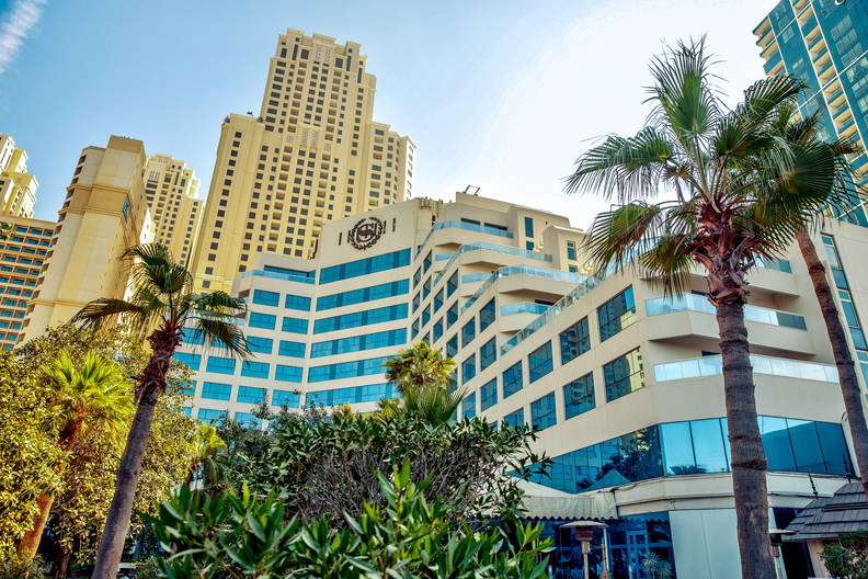 Widok na drapacze chmur i palmy w Dubaju.