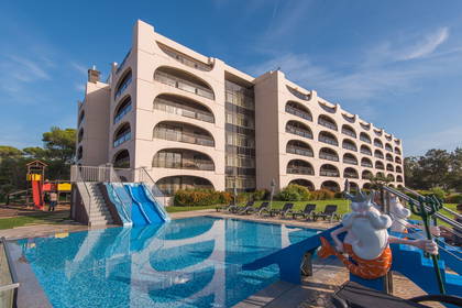 Hotel z basenem, zjeżdżalnią wodną i rzeźbą Neptuna.