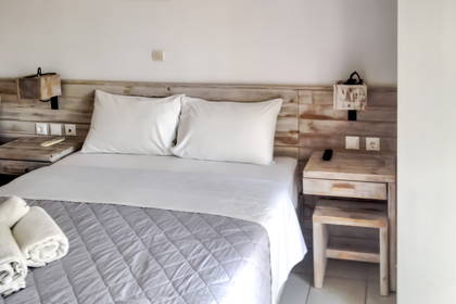 Pokój hotelowy z łóżkiem, szafkami nocnymi i ręcznikami.