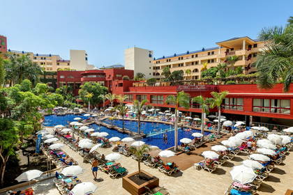 Basen hotelowy z leżakami i parasolami.