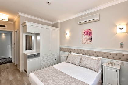 Pokój hotelowy z łóżkiem, szafą i klimatyzacją.