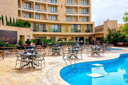 Hotel z basenem i restauracją na świeżym powietrzu.