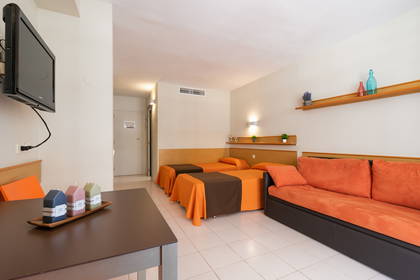 Pokój hotelowy z dwoma łóżkami, kanapą i stolikiem kawowym.