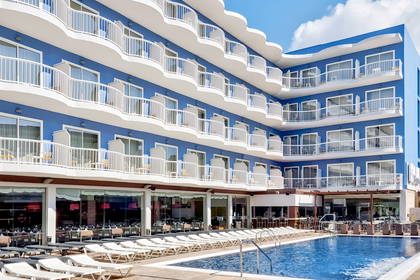 Niebieski hotel z białymi balkonami przy basenie.
