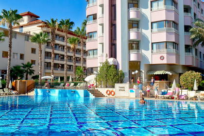 Kompleks hotelowy z basenem w słoneczny dzień.