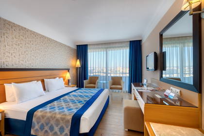 Pokój hotelowy z łóżkiem, biurkiem i oknem.