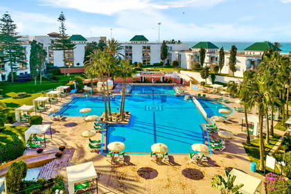 Kompleks hotelowy z basenami i palmami, widok z góry.