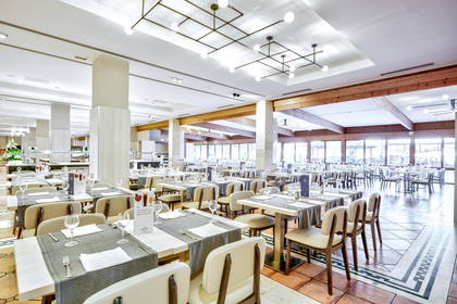 Restauracja z nakrytymi stołami i oknami.