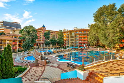 Kompleks hotelowy z basenami i leżakami do opalania.