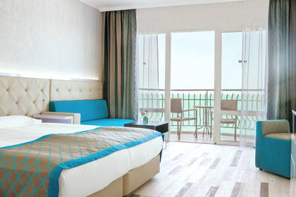 Pokój hotelowy z balkonem i widokiem na ocean.