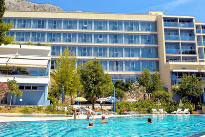 Basen hotelowy pełen ludzi w słoneczny dzień.
