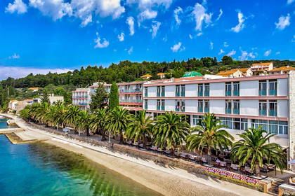 Hotel z palmami przy plaży w Chorwacji.