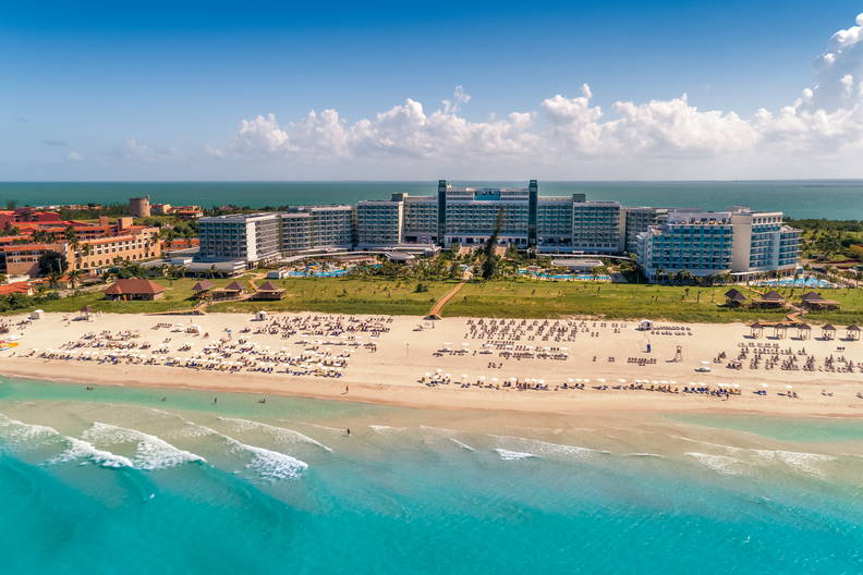 Panorama kurortu z plażą i turkusowym morzem w tle.